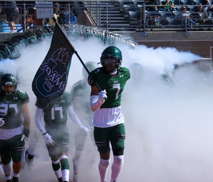 Elijah Harpers leads Adams State onto the field.